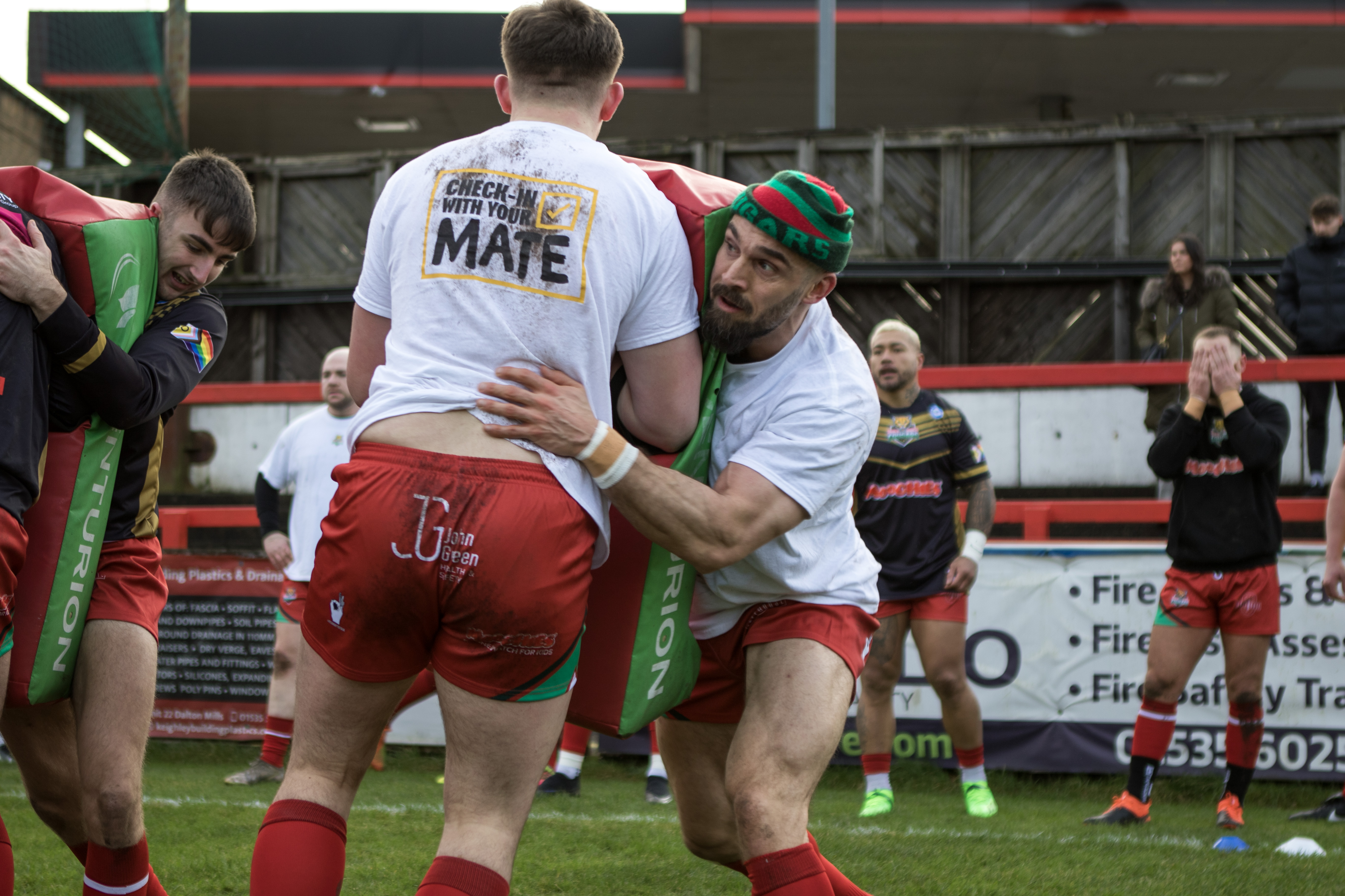 Image shows Cougars warming up on the pitch in Check In With Your Mate T shirts.jpg