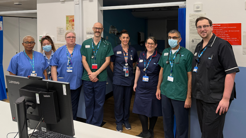 Image of group of people in NHS uniforms smiling