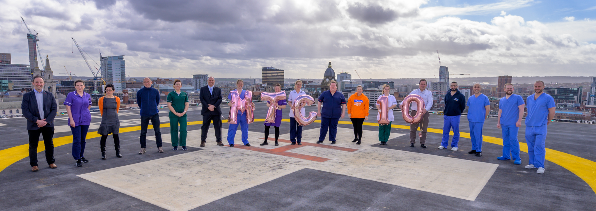 Major Trauma Centre in Leeds marks 10 years of saving lives - colleagues on top of the building holding 10 balloons