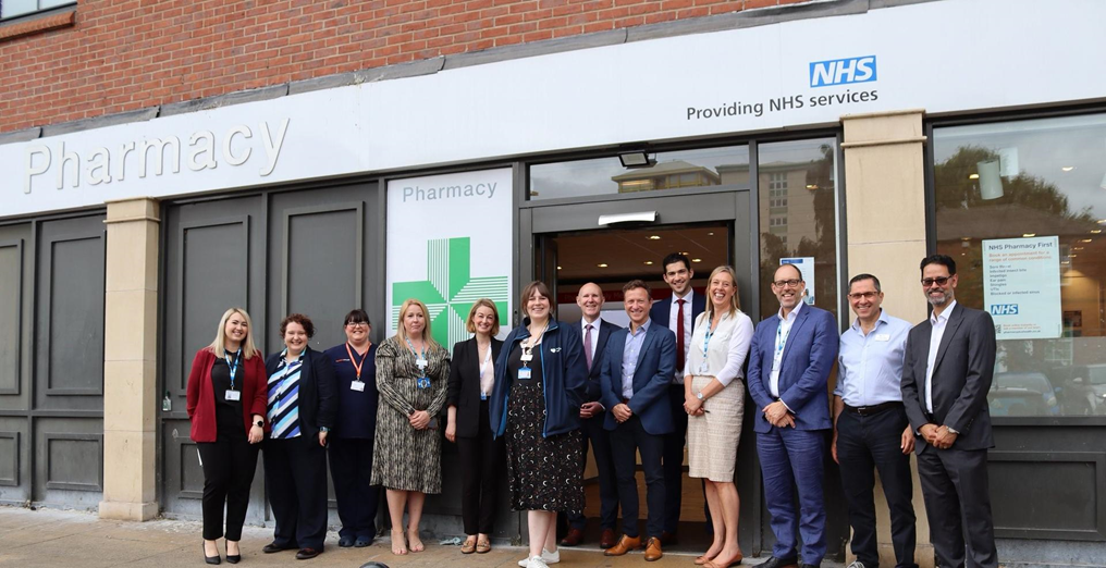 Image of people smiling outside of a pharmacy