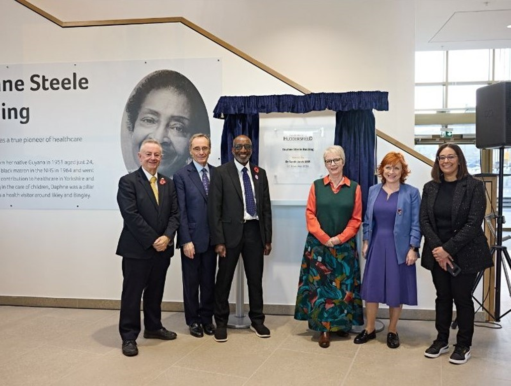 "Group photo of six individuals at the unveiling of the Daphne Steele Building at the University of Huddersfield, honoring Daphne Steele, a pioneering healthcare professional."